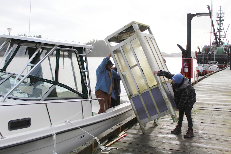 Maude Fillion, left, Stephen McDow, Peter Janssen and Miriah Whitton prepare to transport an old telephone booth from 52 Steps Dock in March 2025. 