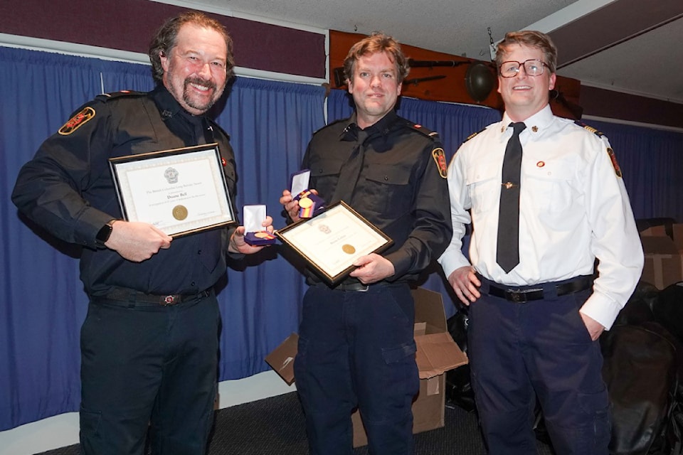 Tofino Volunteer Fire Dept. Chief Mark McKeough, right, presents long service awards to Duane Bell, left, and Donny Collins during a get together in December 2024. Both firefighters have been with Tofino Fire for 25 years. 