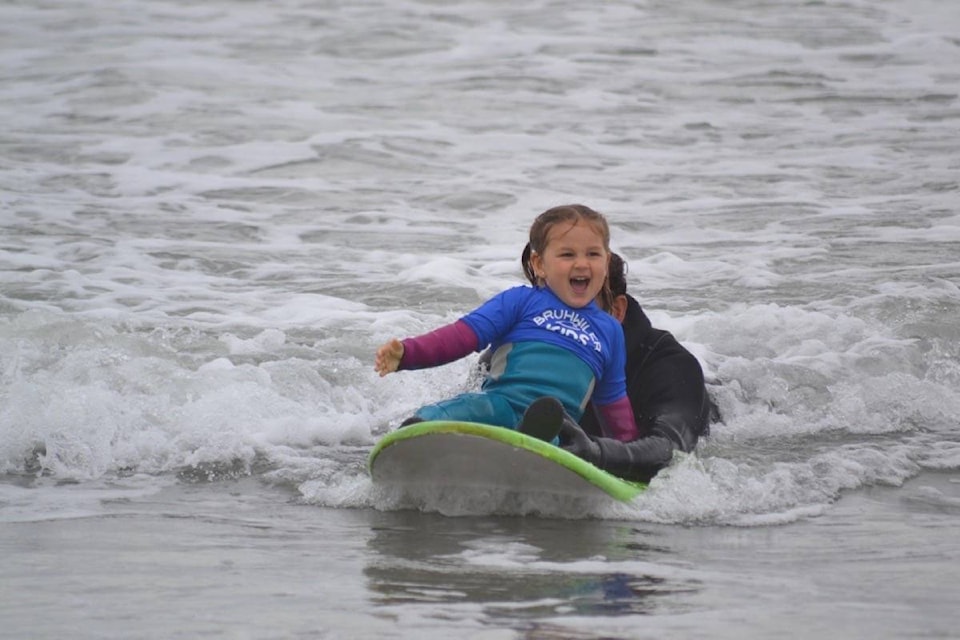 Blake Bruhwiler, 4, howls with joy as her dad Sepp pushes her on a wave. (Nora O’Malley Photos)
