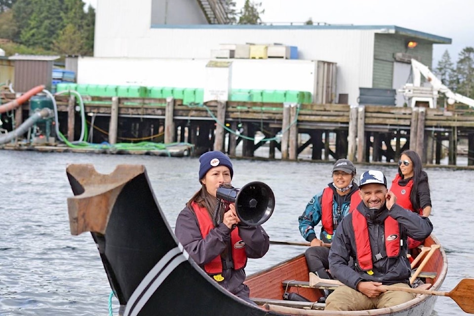 From the bow of a traditional dugout canoe, Tla-o-qui-aht First Nation Tsimka Martin greets over 30 vessels floating for the protection of wild salmon. “The coho are starting to head up for their migration up the rivers now so send them some good energy,” Martin calls out over the megaphone. Martin says DFO is not doing what is right for wild salmon. She wants the organization to recognize that sea lice and diseases are deadly, and to remove salmon farms. (Nora O’Malley photo)