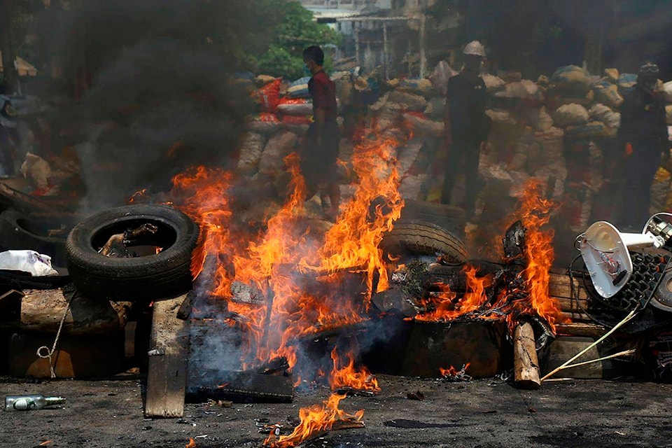 Anti-coup protesters are seen behind their makeshift barricade that protesters burn to make defense line during a demonstration in Yangon, Myanmar, Sunday, March 28, 2021. Protesters in Myanmar returned to the streets Sunday to press their demands for a return to democracy, just a day after security forces killed more than 100 people in the bloodiest day since last month’s military coup. (AP Photo)