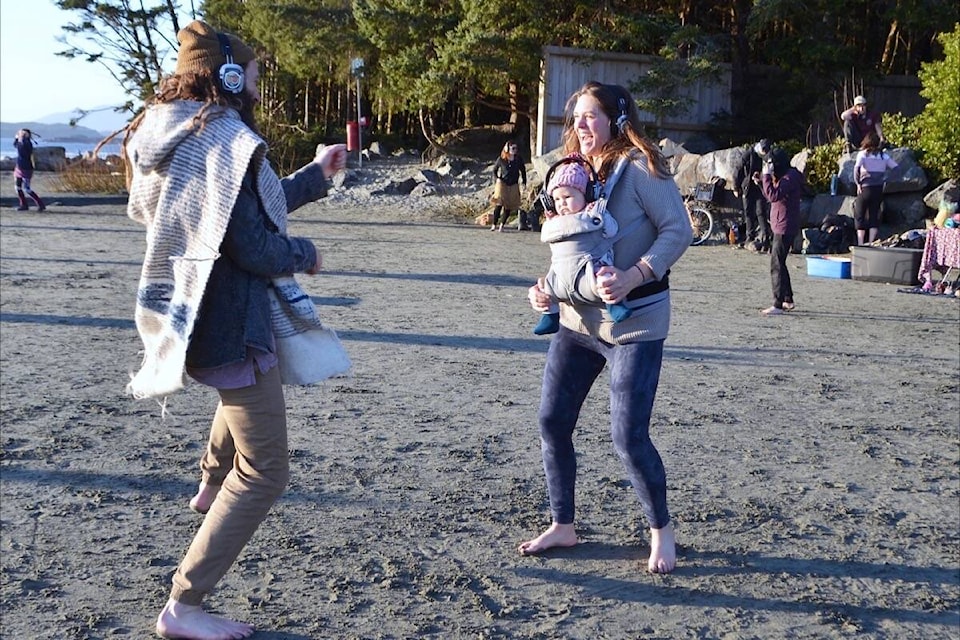 Baby Olaia Mock and her barefooted mom Jamie move and groove on Chesterman Beach during a March 4 headphone community dance party. (Nora O’Malley photo)