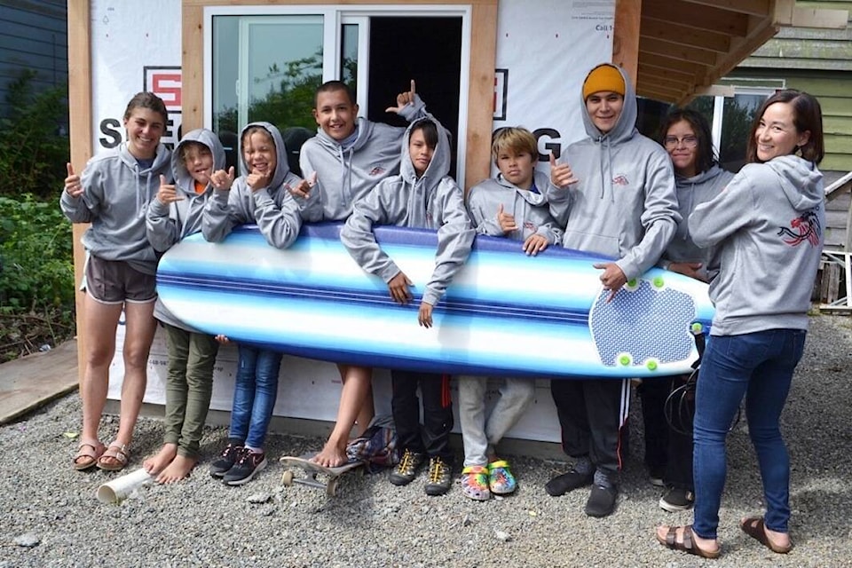 Mułaa surf team members throw shakas in front of their new surf shed at Esowista at the north end of Long Beach. (Nora O’Malley photo)