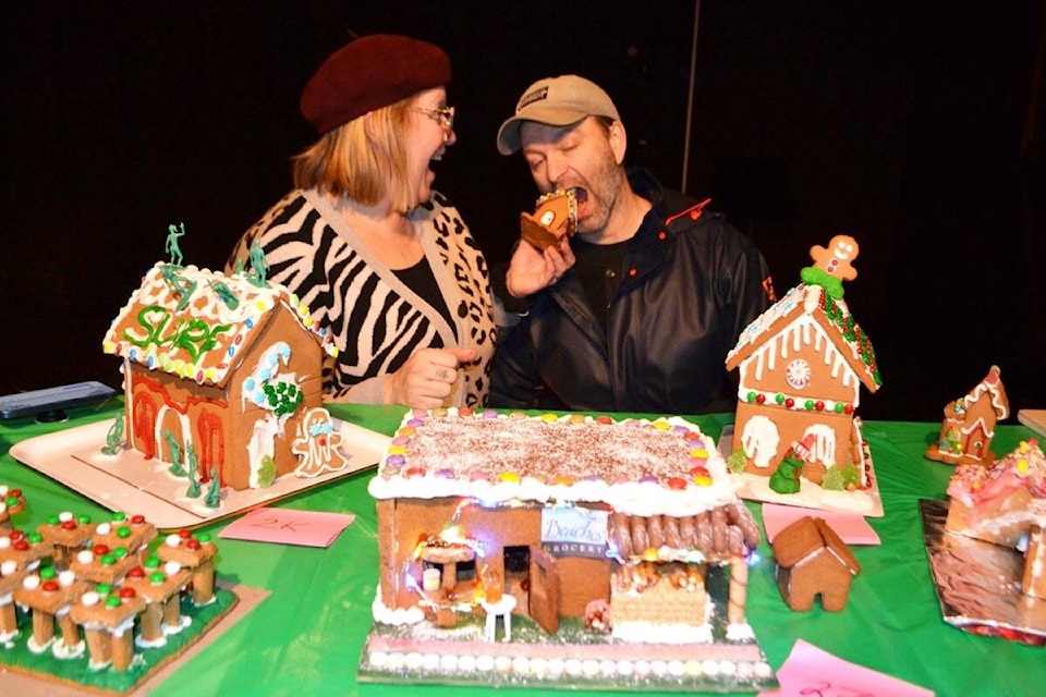 Co-owner of Tofino’s Ouest Artisan Patisserie Jessyca Fulsom feeds partner Stephen Nason a mini gingerbread house on Dec. 2 in the Clayoquot Sound Community Theatre. Ouest received about 26 entries to their gingerbread contest, which showcased edible replicas of town landmarks and buildings. (Nora O’Malley photo)