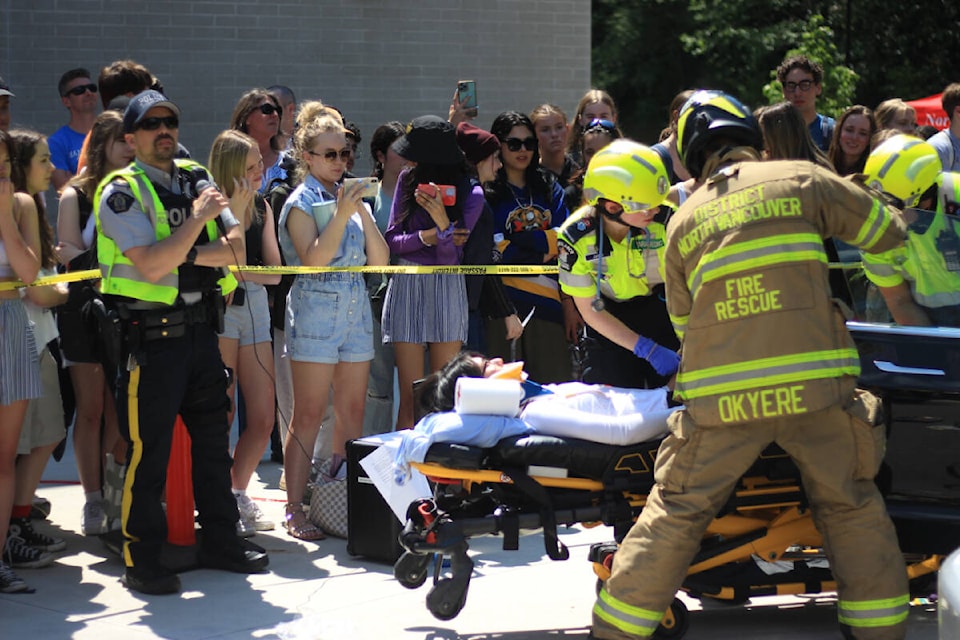 Emergency crews put on a “mock crash” scenario at Handsworth Secondary School in North Vancouver Friday (May 26, 2023) to show students just how serious impaired driving and reckless driving can be. Students look on during the demonstration. (Lauren Collins)