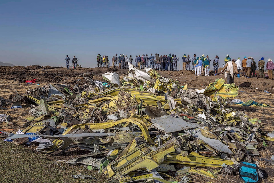 FILE - In this March 11, 2019, file photo, wreckage is piled at the crash scene of Ethiopian Airlines flight ET302 near Bishoftu, Ethiopia. The year since the crash of an Ethiopian Airlines Boeing 737 Max has been a journey through grief, anger and determination for the families of those who died, as well as having far-reaching consequences for the aeronautics industry as it brought about the grounding of all Boeing 737 Max 8 and 9 jets, which remain out of service. (AP Photo/Mulugeta Ayene, File)