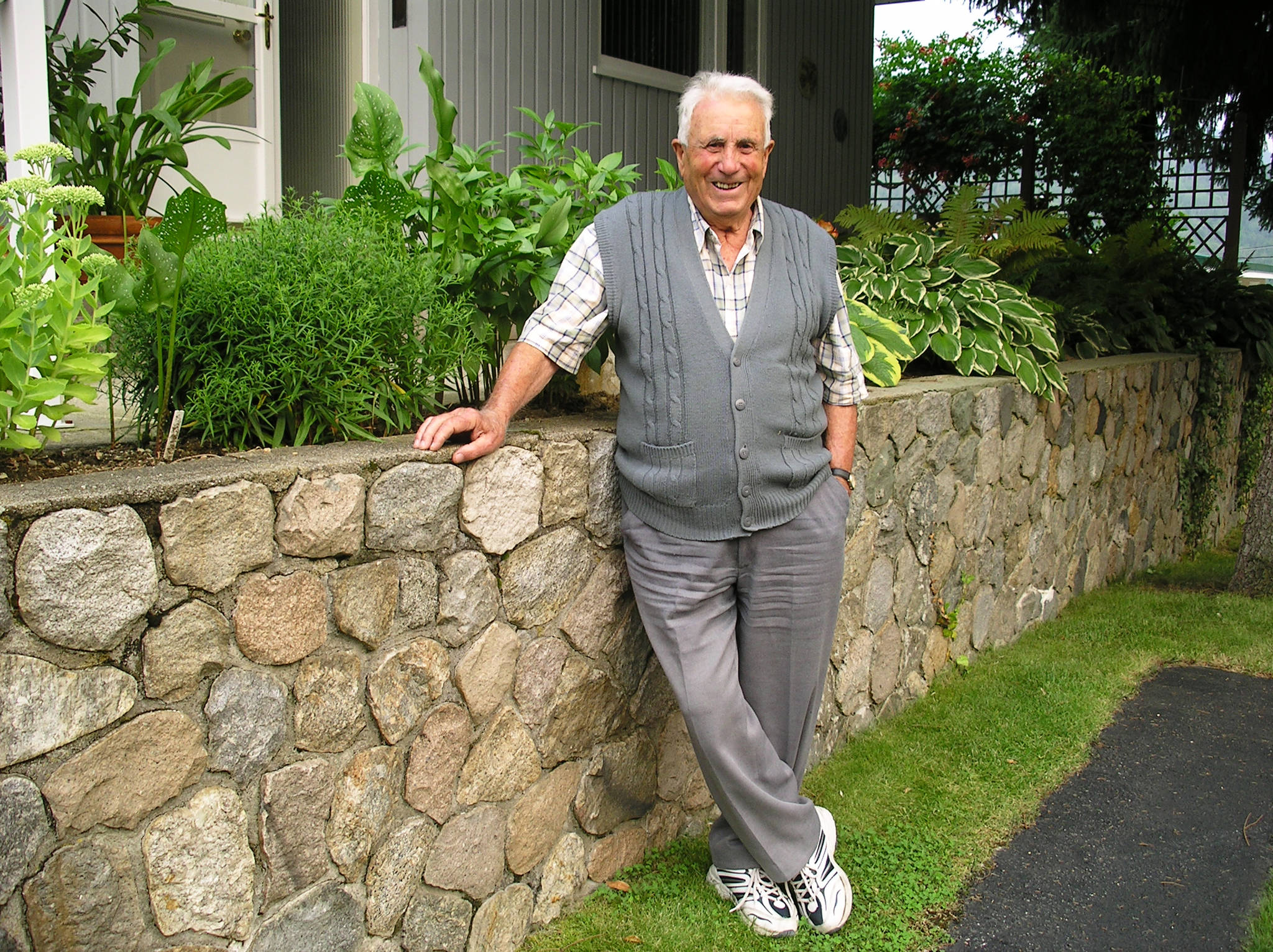 Bill Di Domenico worked as a stonemason for the city and Trail parks. Here he is standing at one of his split river rock walls on Eliot St. in Warfield.(date unknown) Photo: Submitted
