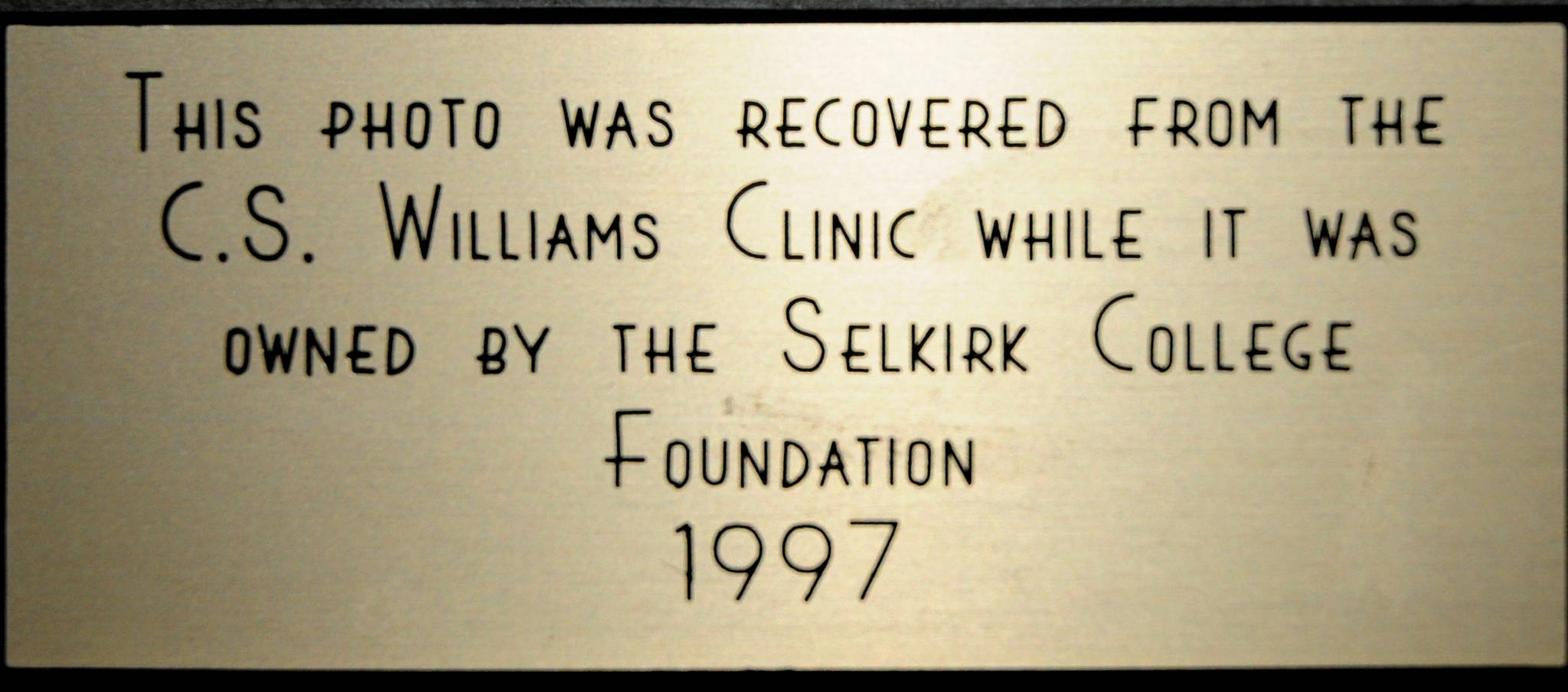 Close up of the inscription mounted below the photo of Trails founding doctors.