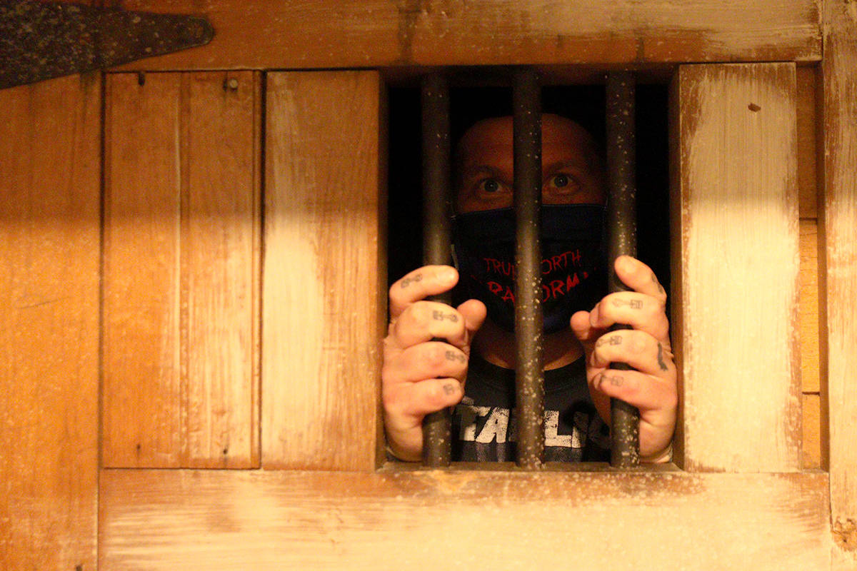Jon Kozuska peers at the camera from inside a basement cell he said once held people awaiting trial in solitary confinement. Photo: Laurie Tritschler