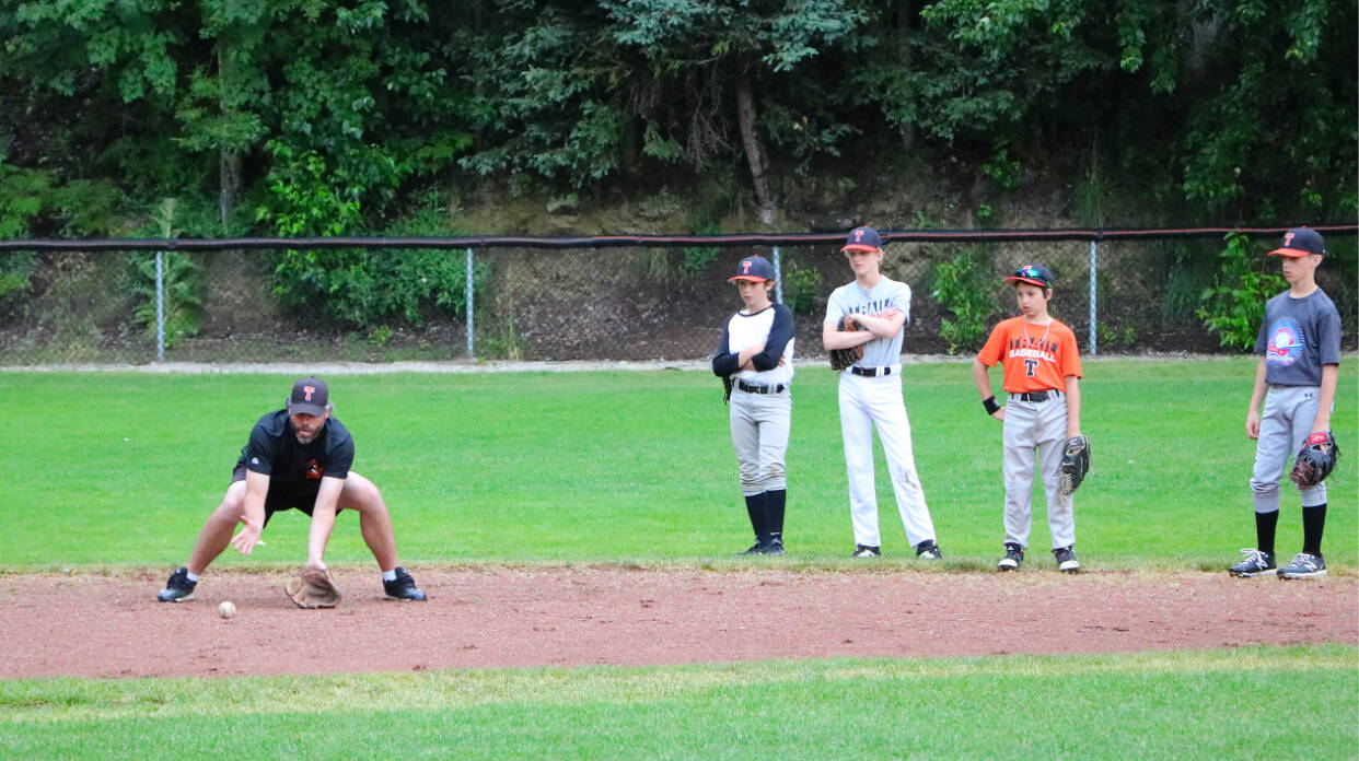 All Stars assistant coach Gary Ortman gives the infield a few tips on positioning during practice Wednesday. Photo: Jim Bailey