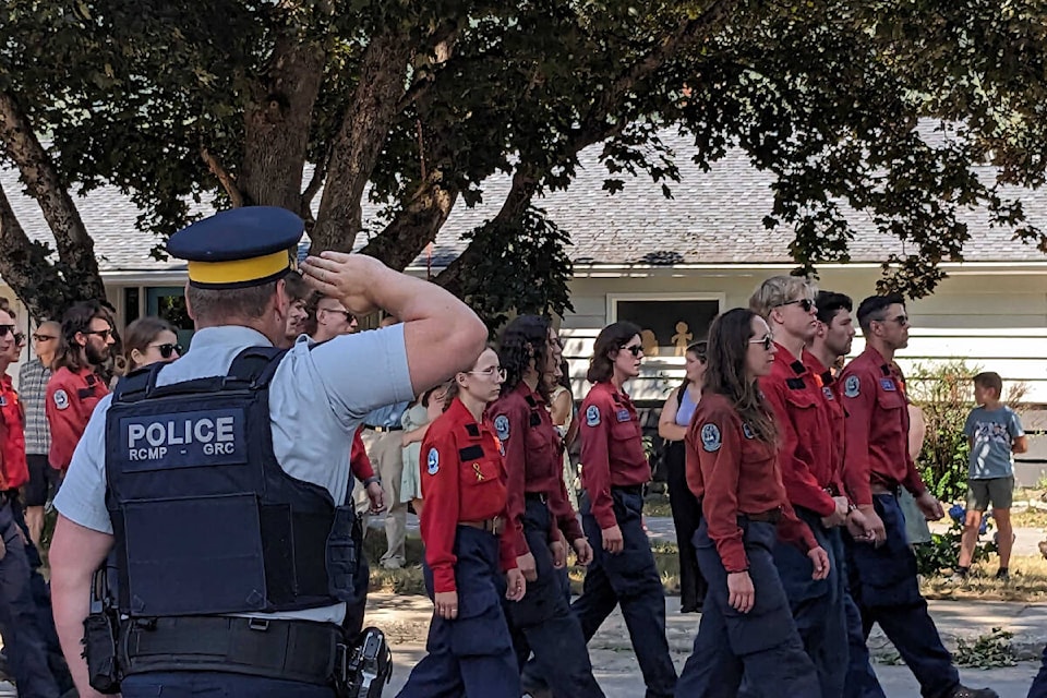 An RCMP officer salutes the memorial processional for 19-year-old Devyn Gale. The procession started at the Revelstoke Fire Rescue Services Hall and continued to Revelstoke Secondary School where Gale graduated just two years earlier. (Josh Piercey)