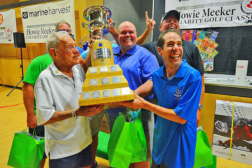 Howie Meeker (left, in white) and Special Olympic athlete Paul Aubuchon (right, in blue) present the winners trophy to the team That’s How We Roll at Saturday’s Howie Meeker Golf Classic. Special Olympians like Aubuchon are matched up with every team and serve as their caddies. The annual event has been raising money for Campbell River Special Olympics for 30 years now and the 94-year-old Meeker has attended every one of them. However, changes are coming to the successful fundraiser. Photo by Alistair Taylor/Campbell River Mirror