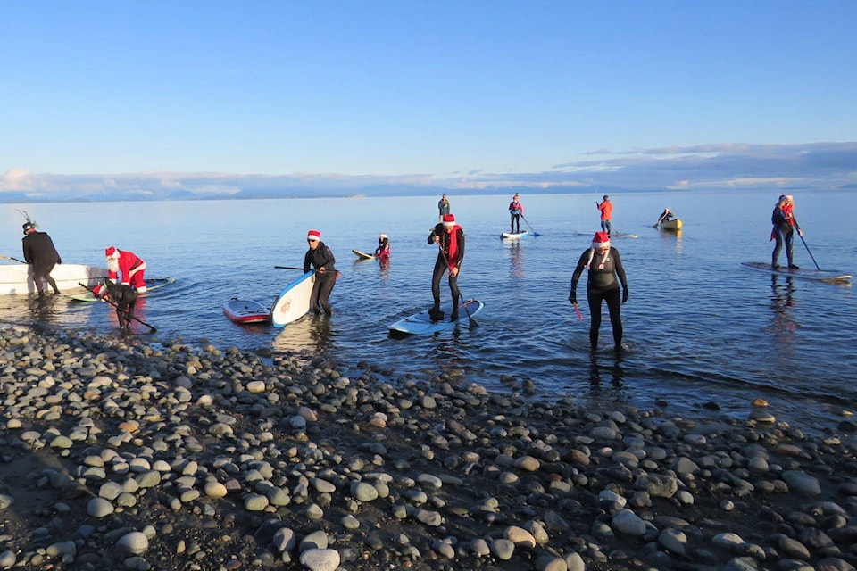 More than 30 people were at Stories Beach Sunday afternoon for the annual Santa Paddle. Photo by Billie Harlow