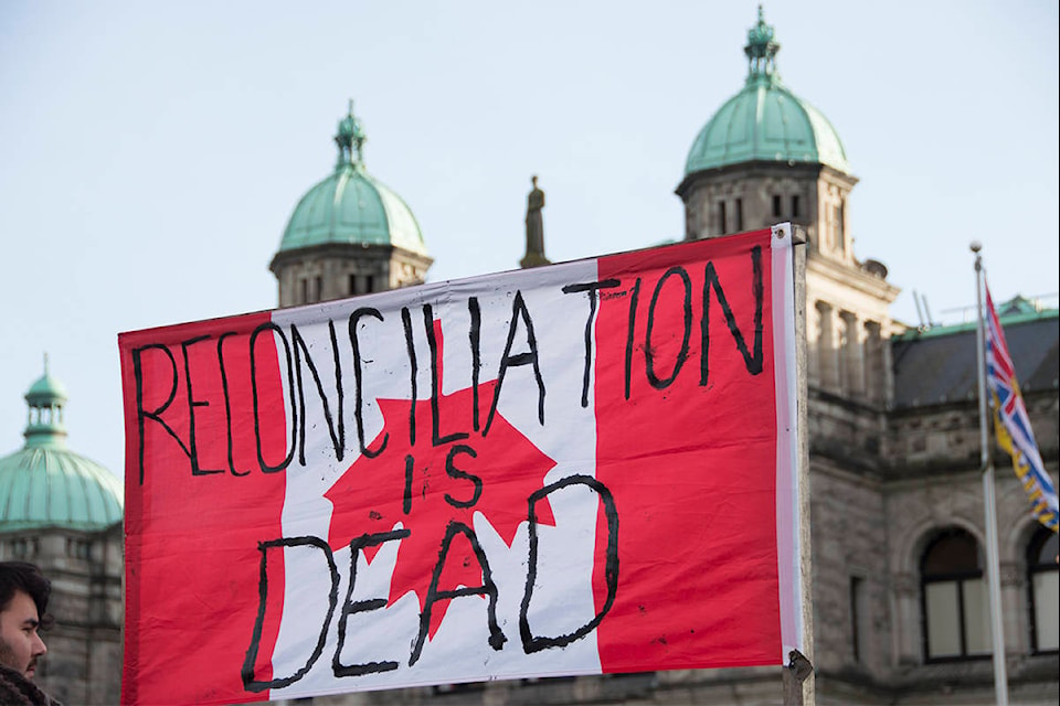 Indigenous land protectors, demonstrators and allies rallied outside the BC Legislature building Monday afternoon on the eve of the throne speech, scheduled for Tuesday morning. The group filled the government building’s fountain with red dye as a representation of “blood on the colonial government’s hands.” (Nina Grossman/News Staff)