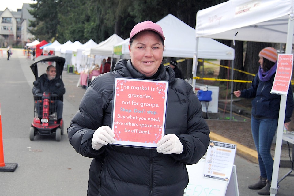 Qualicum Beach Farmers Market manager Launie Elves shows a message to people who came in to purchase items. (Michael Briones photo)