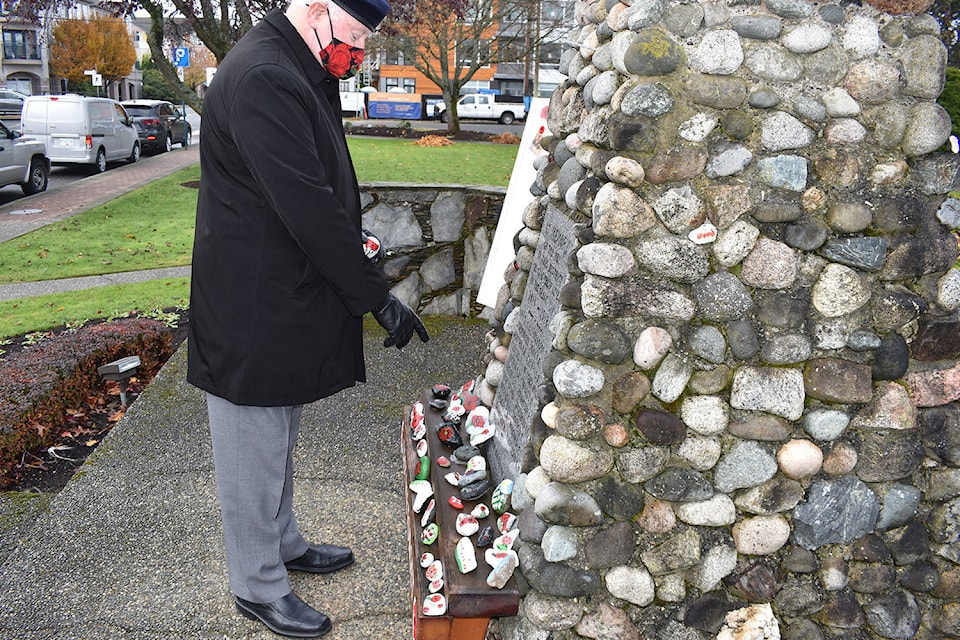 Kenny Podmore of Royal Canadian Legion Saanich Peninsula Branch 37 holds up one of the 40-plus rocks painted with poppies left at Sidney’s cenotaph. (Wolf Depner/News Staff)