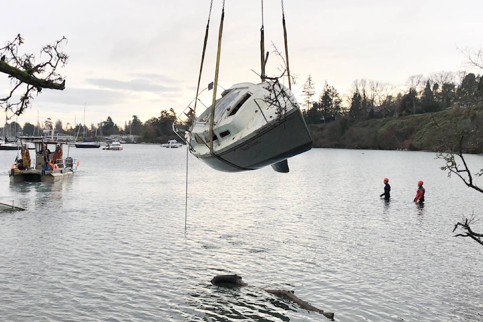 A Salish Sea Industrial crane operator removes a derelict sailboat off the shores of Cadboro Bay on Monday, Dec. 7, 2020. (Travis Paterson/News Staff)