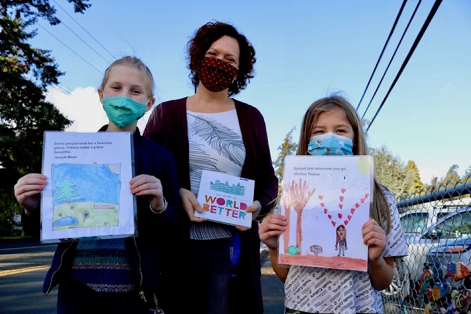 Grade 4 student Ella Baxter-Mohrmann (left), vice-principal Georgie Walker and Lyla Wiltse show the artwork that their Sangster Elementary class created to spread positivity in Colwood. (Aaron Guillen/News Staff)