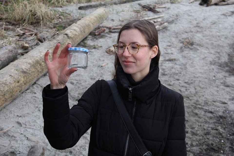Carmen Pavlov, coordinator for Peninsula Streams Society’s BEACH program, holds a sample of a forage fish egg, too small to be seen on camera, but readily visible under microscope. (Christine van Reewyk/News Staff)