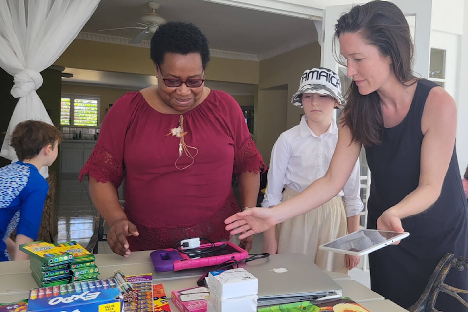 Regan McGrath and the school principal Charmaine Murray go over the technology and school supplies the Victoria family brought for the Askenish All Age School in Hanover Parish, Jamaica. (Courtesy Regan McGrath)