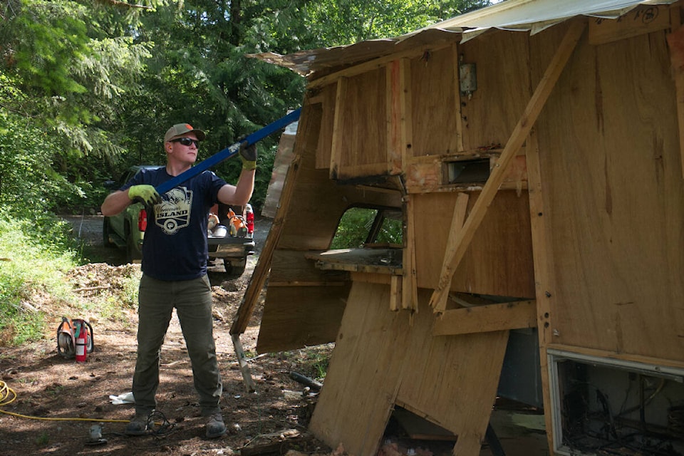 Steve Nikirk, and other members of B.C. Backcountry Hunters and Anglers, were part of efforts to clean up areas off of Claymore Road in Qualicum Beach on June 12, 2022. Nikirk is seen here disassembling an abandoned motor home. (Kevin Forsyth photo).