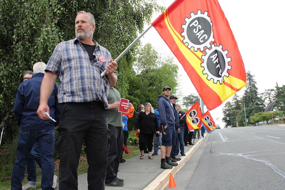 CFB Esquimalt workers and those in solidarity rally outside the naval base Wednesday. Their union leader called the federal government’s most recent wage negotiation offer insulting. (Jake Romphf/News Staff)