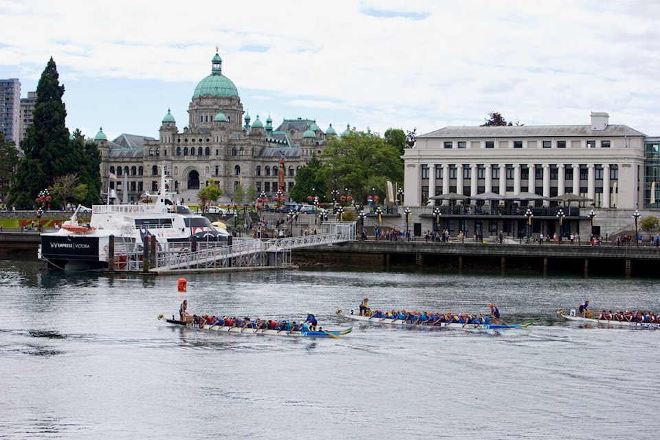 A trio of dragon boats cross the finish line overlooked by the legislature building Saturday during the Victoria Dragon Boat Festival. (Justin Samanski-Langille/News Staff)