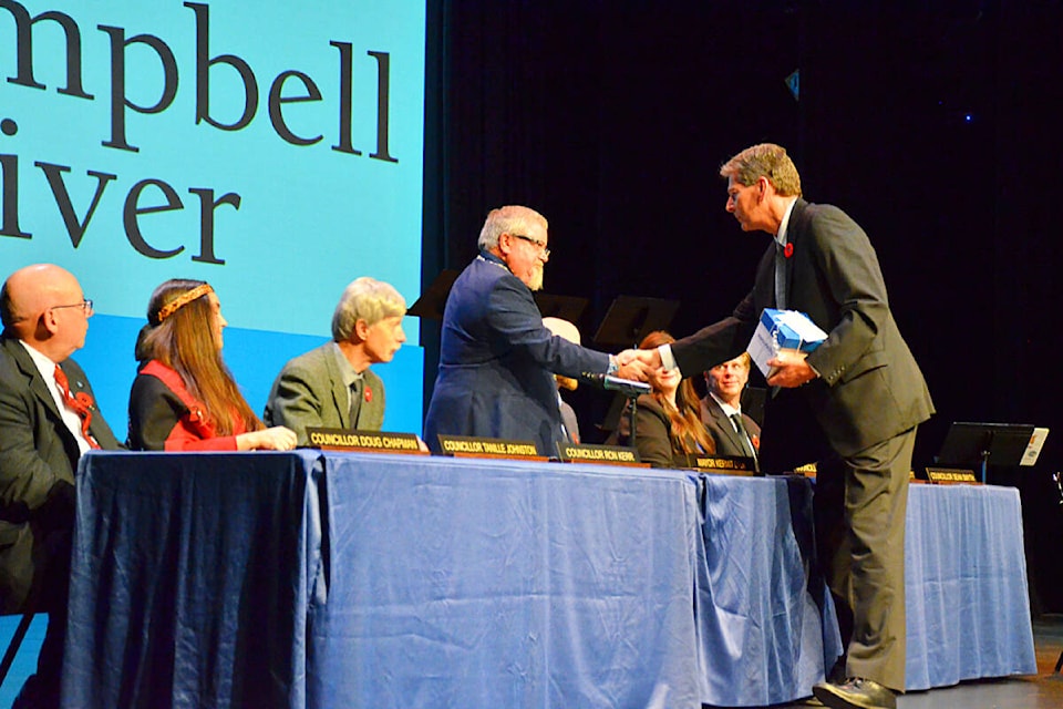 Outgoing mayor Andy Adams (right) received a gift for his service and then congratulated new mayor Kermit Dahl and his new city council at the Inaugural Council Meeting at the Tidemark Theatre Nov. 1, 2022. Photo by Alistair Taylor/Campbell River Mirror