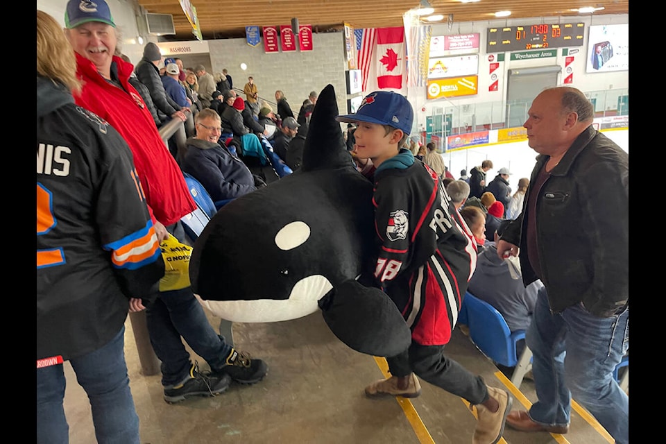 Dalyn Fredrickson carts a giant orca up the stairs at the Alberni Valley Multiplex during the second period intermission of the Alberni Valley Bulldogs’ teddy bear toss game on Friday, Dec. 2, 2022. Fredrickson had to wait until the final buzzer to throw his whale onto the ice as the ‘Dogs were shut out 5-0. (SUSAN QUINN/ Alberni Valley News)