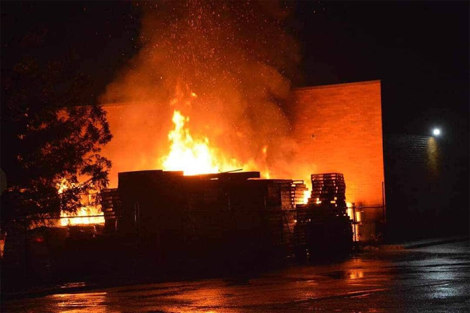 Flames shoot from two storage sheds behind Westcoast Home Hardware around 3 a.m. Saturday, Nov. 4, 2023. (JERRY FEVENS PHOTO)