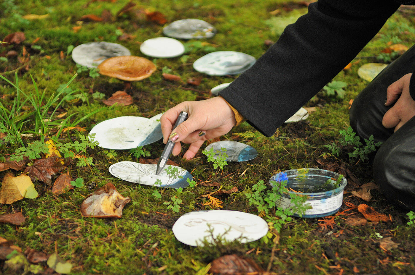 Tracie Stewart with Choreography of Trust, an international collective of women artists, uses water from a nearby stream and rainwater while drawing outside at Cultus Lake on Tuesday, Sept. 26, 2023. (Jenna Hauck/ Chilliwack Progress)