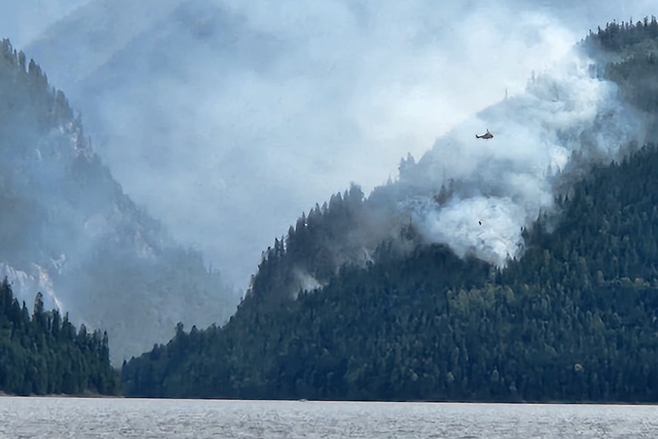 A helicopter buckets the Sitkum Creek wildfire near Cherryville. 