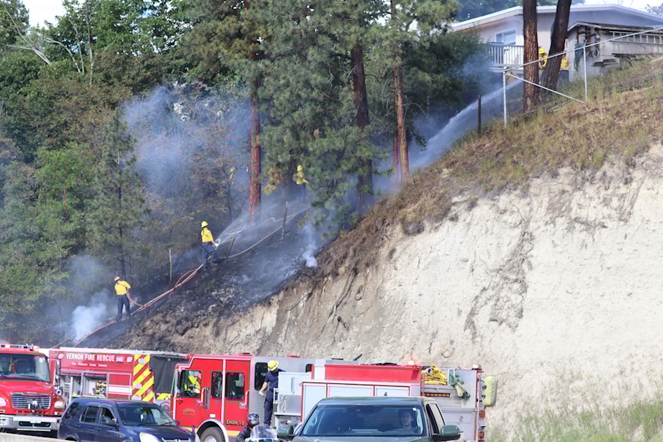 Firefighters tackle a fast-moving grass fire on 27th Street near Highway 6 June 24.