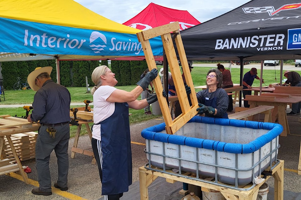 Volunteers Shauna Donnachie (left) and Martina Putzer stain a frame at the Knights of Columbus Coldstream build a bed event Saturday, June 22, at Our Lady of the Valley Church in Coldstream. The event was held in conjunction with the Vernon chapter of Sleep in Heavenly Peace, which builds beds for Greater Vernon youth aged 3-17 that don't have beds to sleep on. 