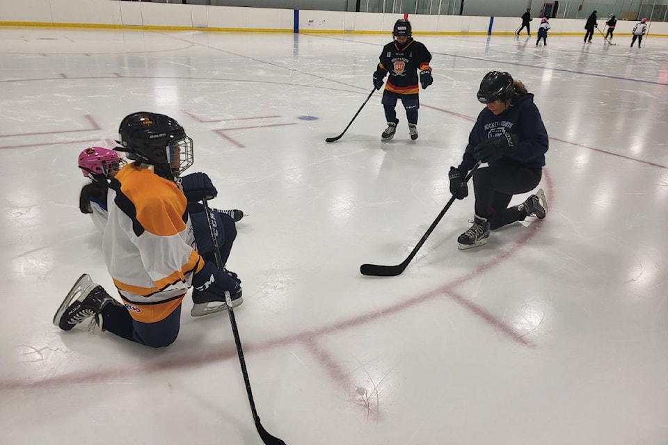 Volunteer coach Derry Ann Cooper (right) goes over some skating tips for first time skaters/hockey players at the start of the 2024 Larry Kwong Memorial Hockey 4 Youth Program Tuesday, Oct. 1, at the Priest Valley Arena.