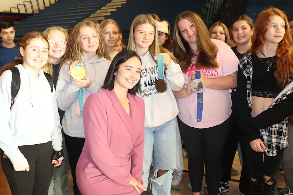Canadian Olympic gold medalist and World Champion figure skater Kaetlyn Osmond (kneeling) shares her Olympic medals with students following a presentation at Vernon Secondary School Thursday, Oct. 10.