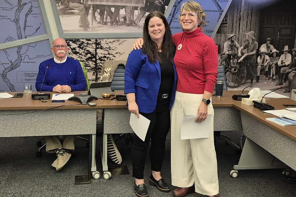 Outgoing Okanagan Basin Water Board executive director Anna Warwick Sears (right) share a hug with her successor, Melissa Tesche, as board chair Blair Ireland looks on, during the board's meeting Tuesday, April 1, in Coldstream.