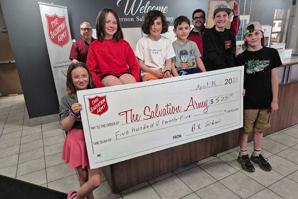 Vernon BX Elementary School students Riva Holowach (front row, from left), Maxine Dahlie, Dominic P., Lukas Lypchuk, Liam Lypchuk, and Keenan Cooper present Vernon  Salvation Army representatives Paul Bielby (back row, left) and Randel Erbacker (with crate) with $525, the proceeds raised from the school's wooden crate kindness project.