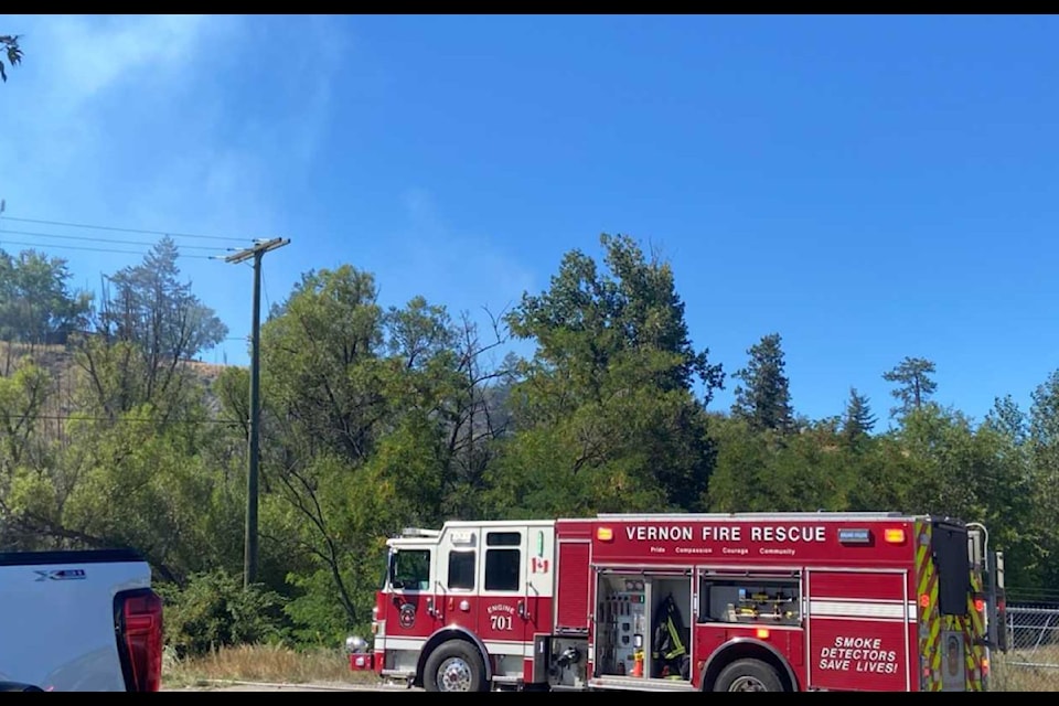 Vernon Fire Rescue Services crews are working to knock down a fire in the trees behind Kal Tire's head office off Kalamalka Lake Road in Vernon, as of 3:30 p.m. Monday, Aug. 11.