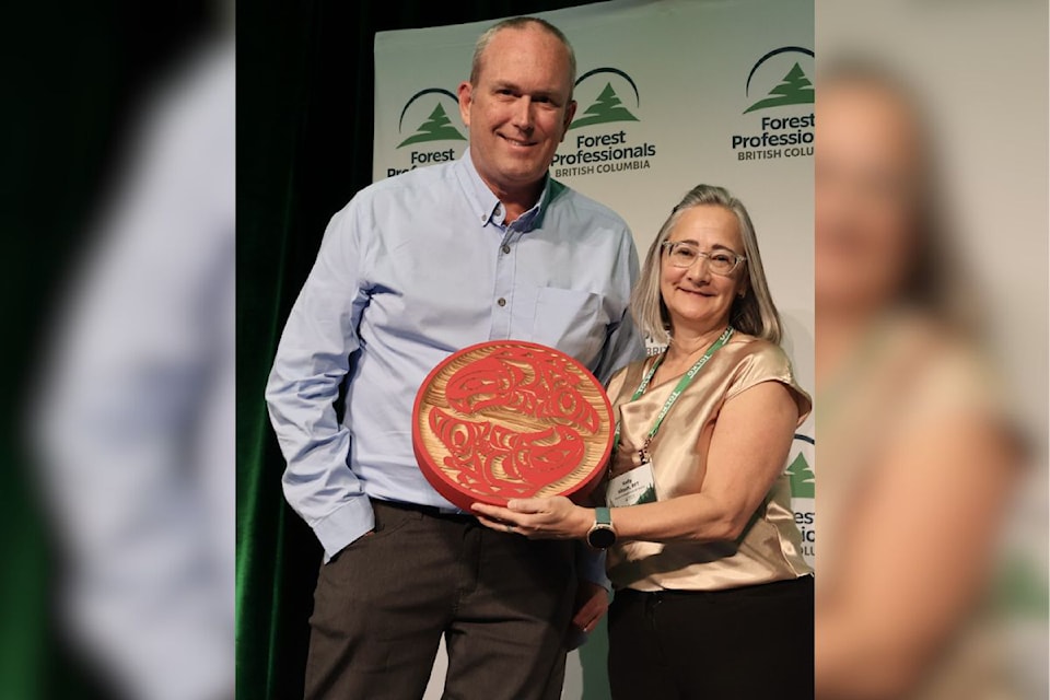 Vernon Registered Professional Forester Mark Hay (left) receives a gift for being recognized as a Distinguished Forest Professional from Kelly Kitsch, past board chair of Forest Professionals British Columbia at the 77th FPBC conference in  Victoria Thursday, Feb. 6.