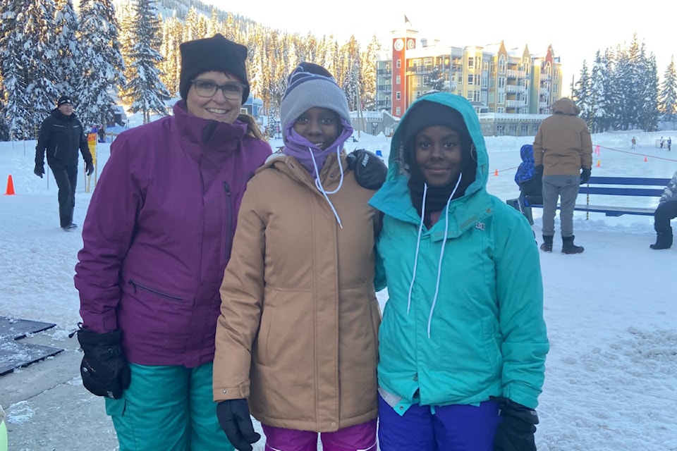 Left to right: Heidi Lockhart with her friends' adopted daughters Josephine and Caroline Randolph. The Ugandan twins experienced snow for the first time on a recent trip to Canada that ended with a day up at Vernon's SilverStar Mountain Resort in January 2025. 