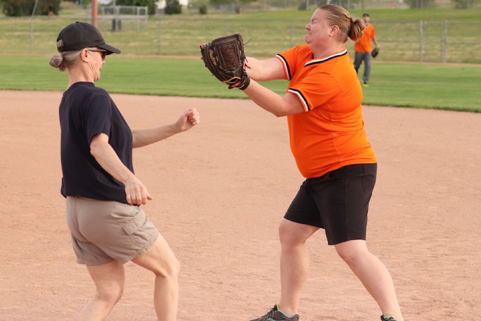 Vernon Special Olympics Tigers first baseman Erika Wamsteeker (right) makes a nifty catch to put out Vernon North Okanagan RCMP batter Cpl. Tania Finn during the Tigers' 21-6 victory in an exhibition softball game Thursday, June 19, at the Vernon Army Camp.