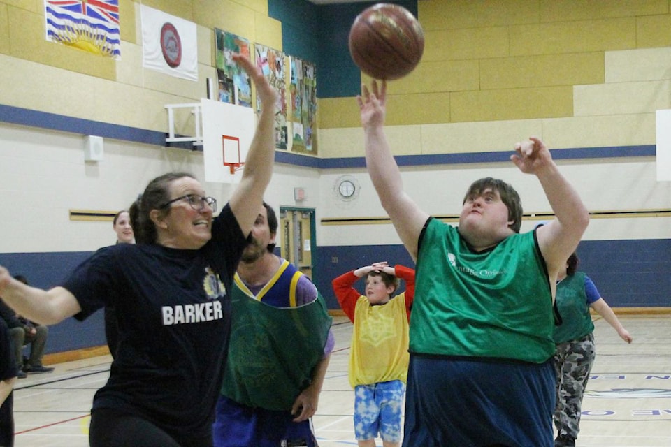 Special Olympics BC ѻý Vernon forward Sterling Bryant (right) gets a shot away before Vernon North Okanagan RCMP Const. Krista Boudreau can block it during a friendly exhibition basketball game between the two organizations played Monday, March 3, at Ellison Elementary School.