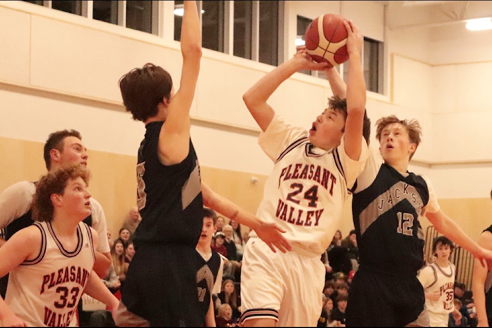 Jacob Baird (24) of Armstrong's Pleasant Valley Hawks goes up for a tough shot against Salmon Arm J.L. Jackson Jays defenders Zeka Neufeld (left) and Kyle Sexsmith during North Zone Junior Boys Basketball League action Thursday, Jan. 9. The game, won by the Jays, was the first in PVSS' new gymnasium. Baird scored the Hawks' first basket in the new facility.