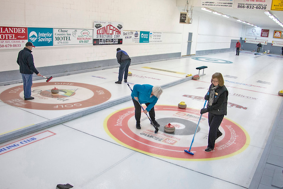 Curlers sweep their team’s rocks into the house. (Rick Koch photo)
