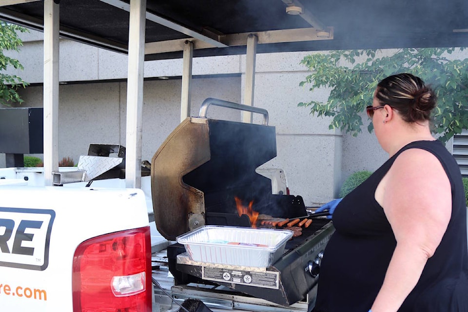 Steph Shields cooks burgers and hot-dogs at Brain Trust Canada BBQ Fundraiser. (Jennifer Blake - Morning Star)