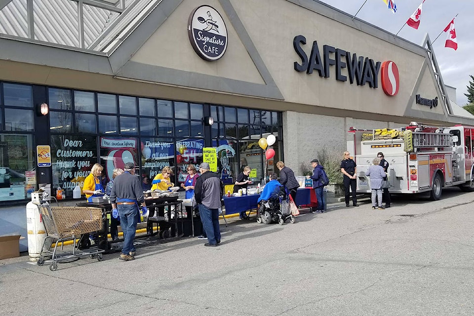 The Vernon Lions Club was on hand Thursday at Vernon’s downtown Canada Safeway to prepare hamburgers and hot dogs as the store paid appreciation to 54 years of employee and customer support with a lunch by donation. (Roger Knox - Morning Star)