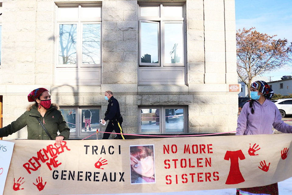 An RCMP officer walks to the Vernon courthouse entrance behind a group of protesters calling for justice for missing and murdered Indigenous women in the North Okanagan Thursday, Jan. 7, 2021. (Brendan Shykora - Morning Star)