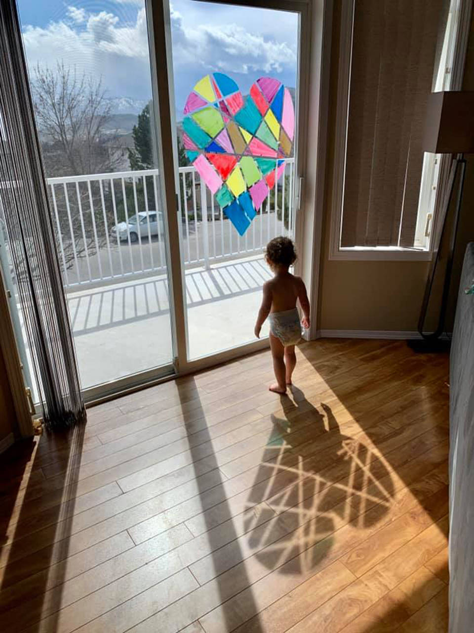 Tasia Evans took this powerful photo of her baby standing in the shadows of the heart they had created on their window in March 2020 when we were told not go outside to parks or gather.