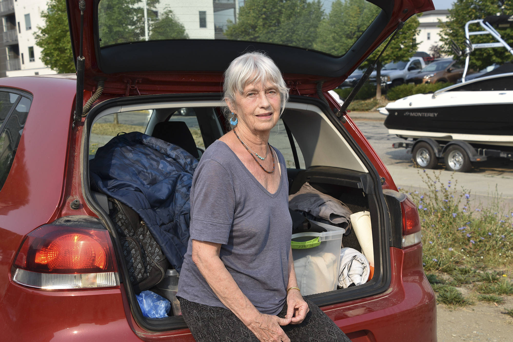 Rose Bleuer, one of the Falkland evacuees from the White Rock Lake wildfire, sits with her fully packed car on Aug. 5 outside Salmon Arms Prestige Harbourfront Resort, where the Emergency Support Services reception centre is located. (Martha Wickett - Salmon Arm Observer)